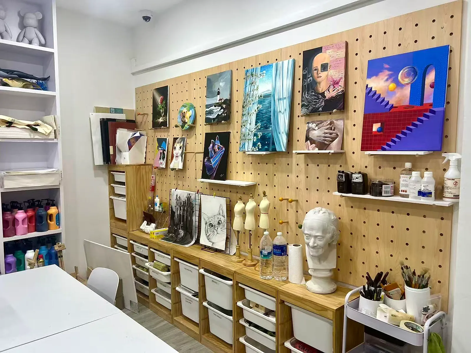 GaiaX studio wall with student paintings, casts and materials